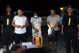 Lực lượng công an bắt các đối đối tượng trong đường dây mua, bán giấy tờ giả. (Ảnh: Tường Quang/TTXVN phát)