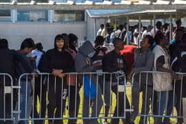 Người di cư xếp hàng nhận lương thực cứu trợ tại Calais, Pháp. (Nguồn: AFP/TTXVN)