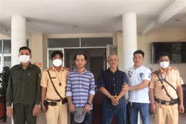 Trạm Cảnh sát giao thông thị xã Trảng Bàng tổ chức bàn giao 2 đối tượng trộm ôtô cho Công an thành phố Tây Ninh. (Ảnh: Thanh Tân/TTXVN)