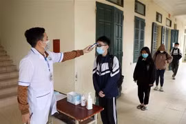 Đo thân nhiệt cho học sinh. (Nguồn: TTXVN)