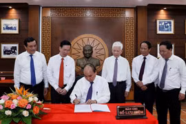 Chủ tịch nước Nguyễn Xuân Phúc viết lưu bút tại Khu lưu niệm Chủ tịch Hội đồng Nhà nước Võ Chí Công, thôn Khương Mỹ, xã Tam Xuân 1, huyện Núi Thành. (Ảnh: Thống Nhất/TTXVN)