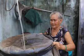Người dân che đậy dụng cụ chứa nước, không để muỗi có chỗ sinh sản. (Ảnh: Nhựt An/TTXVN)