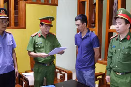 Lực lượng chức năng đọc quyết định khởi tố đối với bị can Đỗ Khắc Điệp. (Ảnh: TTXVN phát)