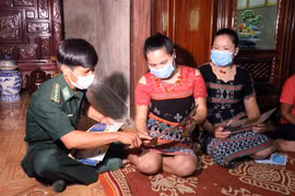 Cán bộ quân y ở Trạm xá Quân dân y kết hợp tuyên truyền về sức khỏe sinh sản và vận động chị em phụ nữ không sinh con thứ ba. (Ảnh: Đỗ Trưởng/TTXVN)