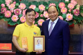 Chủ tịch nước Nguyễn Xuân Phúc tặng chân dung Chủ tịch Hồ Chí Minh cho đoàn viên thanh niên tiêu biểu. (Ảnh: Thống Nhất/TTXVN)