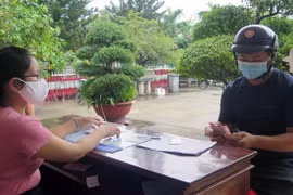 Chi trả tiền hỗ trợ người dân bị ảnh hưởng bởi dịch COVID-19. (Nguồn: TTXVN)