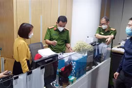 Lực lượng chức năng khám xét và thu giữ tài liệu tại trụ sở FLC hôm 29/3. (Ảnh: Phạm Kiên/TTXVN)