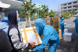 Người dân gửi các nhu yếu phẩm thiết yếu cho đội ngũ y tế tại khu vực bị cách ly, phong tỏa. (Ảnh: Trần Lê Lâm/TTXVN)