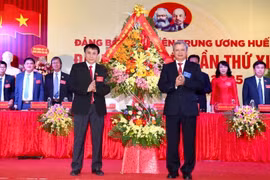 Ủy viên Trung ương Đảng,Bí thư Tỉnh ủy Thừa Thiên-Huế Lê Trường Lưu (phải) tặng hoa chúc mừng Đại hội. (Ảnh: Mai Trang/TTXVN)