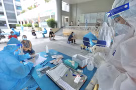 Nhân viên y tế lấy mẫu cho người dân phường Yên Hòa (quận Cầu Giấy). (Ảnh: Minh Quyết/TTXVN)