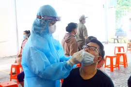 Cán bộ y tế lấy mẫu xét nghiệm cho người dân. (Ảnh: Tá Chuyên/TTXVN)