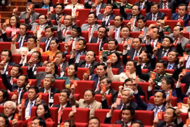Các đại biểu biểu quyết, thông qua Nghị quyết Đại hội XIII Đảng Cộng sản Việt Nam. (Ảnh: TTXVN)