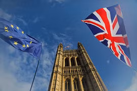 Cờ Anh (phải) và cờ EU tại London, Anh, ngày 17/10/2019. (Ảnh: AFP/TTXVN)