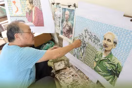 Họa sỹ Đỗ Lệnh Tuấn miệt mài bên bức tranh ghép tem về Chủ tịch Hồ Chí Minh. 