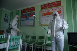 Nhân viên y tế phun thuốc khử trùng nhằm ngăn chặn sự lây lan của dịch COVID-19 tại Bình Nhưỡng, Triều Tiên. (Ảnh: AFP/TTXVN)
