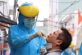 Cán bộ y tế lấy mẫu xét nghiệm cho người dân. (Ảnh: Quốc Dũng/TTXVN)