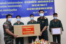 Thiếu tướng Nguyễn Trường Thắng, Phó Tư lệnh Quân khu 7 trao tặng vật tư y tế chống dịch COVID-19 cho Quân khu 4 Quân đội Hoàng gia Campuchia. (Ảnh: Lê Đức Hoảnh/TTXVN)