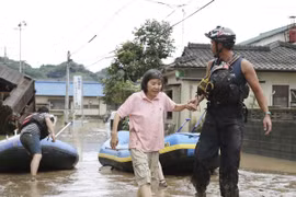 Nhân viên cứu hộ hỗ trợ người dân sơ tán khỏi vùng ngập lụt tại tỉnh Kumamoto, Nhật Bản ngày 4/7/2020. (Ảnh: Kyodo/TTXVN)