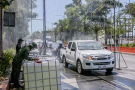 Các phương tiện được phun khử khuẩn trước khi di chuyển vào thủ đô Manila, Philippines ngày 23/3/2020. (Ảnh: THX/TTXVN)