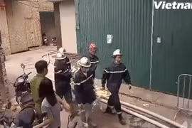 Lực lượng phòng cháy chữa cháy đưa thi thể các nạn nhân ra ngoài. (Ảnh: PV/Vietnam+)