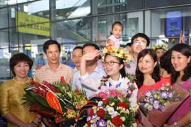 Nguyễn Khánh Linh cười tươi giữa bạn bè, thầy cô và người thân đi đón tại sân bay Nội Bài. (Ảnh: Thanh Tùng) 