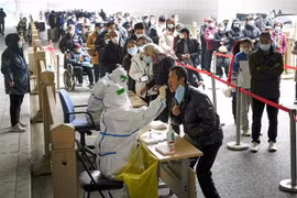 Nhân viên y tế lấy mẫu xét nghiệm COVID-19 cho người dân tại Bắc Kinh, Trung Quốc. (Ảnh: Kyodo/TTXVN)