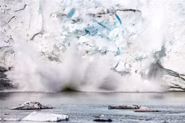 Băng tách ra từ một núi băng trên sông băng Apusiajik, gần Kulusuk, phía Đông Nam đảo Greenland. (Ảnh: AFP/TTXVN)
