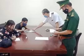 Lực lượng chức năng làm việc với Ngô Văn Hồng và Phan Thị Anh. (Ảnh: TTXVN phát)