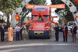 Các đại biểu thực hiện nghi thức kéo dải lụa đỏ cho xe chạy xuất khẩu container macca Krông Năng đầu tiên. (Ảnh: Hoài Thu/TTXVN)