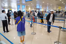 Hành khách tuân thủ khoảng cách tối thiểu 2m khi làm thủ tục tại sân bay Nội Bài sau hai ngày nới lỏng giãn cách xã hội. (Ảnh: Phan Công/Vietnam+)