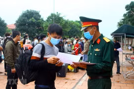 Trao “Giấy chứng nhận hoàn thành việc cách ly phòng bệnh COVID-19” cho các công dân đã hoàn thành thời gian 14 ngày cách ly theo quy định của Bộ Y tế. (Ảnh: Tá Chuyên/TTXVN)