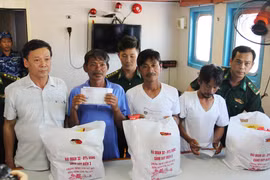 Đại diện địa phương Khánh Hòa trao quà hỗ trợ cho 4 ngư dân gặp nạn may mắn sống sót sau gần 10 ngày lênh đênh trên biển. (Ảnh: Phan Sáu/TTXVN)