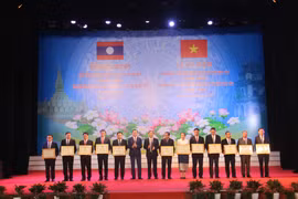 Bí thư Tỉnh uỷ Hà Tĩnh Hoàng Trung Dũng và Chủ tịch UBND tỉnh Hà Tĩnh Võ Trọng Hải trao Bằng khen cho các tập thể và cá nhân thuộc nước CHDCND Lào đã có thành tích trong việc vun đắp mối quan hệ đặc biệt Việt Nam-Lào. (Ảnh: Hoàng Ngà/TTXVN)