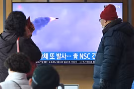 Người dân theo dõi qua truyền hình ở nhà ga Seoul (Hàn Quốc) về vụ phóng vật thể chưa xác định của Triều Tiên, sáng 27/2/2022. (Ảnh: AFP/TTXVN)
