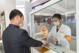 Khử khuẩn tay, đo thân nhiệt, nhằm ngăn chặn sự lây lan của dịch COVID-19 trước khi vào trung tâm thương mại ở Bình Nhưỡng, Triều Tiên. (Nguồn: AFP/TTXVN)