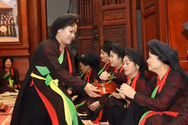 Liền chị quan họ Thị Cầu mời trầu tại canh hát quan họ. (Ảnh: Thái Hùng/TTXVN)