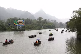 Những con đò tiếp nối nhau trên suối Yến, đưa du khách hành hương lễ Phật. (Ảnh: Thành Đạt/TTXVN) 