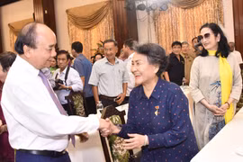 Chủ tịch nước Nguyễn Xuân Phúc giao lưu cùng các đại biểu tại buổi họp mặt. (Ảnh: Thu Hương/TTXVN) 