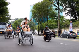 Du khách quốc tế tham quan trung tâm Thành phố Hồ Chí Minh bằng xích lô. (Ảnh: Hồng Đạt/TTXVN) 