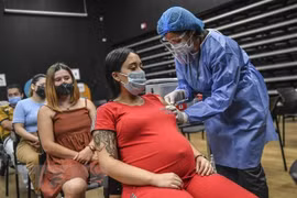 Nhân viên y tế tiêm vaccine ngừa COVID-19 của Pfizer-BioNTech cho phụ nữ mang thai tại Medellin, Colombia. (Ảnh: AFP/TXVN) 