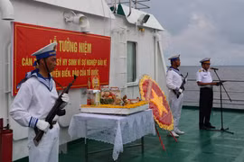 Các đại biểu kiều bào tham dự Lễ tưởng niệm cán bộ, chiến sỹ hy sinh tại quần đảo Trường Sa vì sự nghiệp bảo vệ chủ quyền biển, đảo Tổ quốc trong không khí nghiêm trang và xúc động tại boong tàu Trường Sa 571. (Ảnh: Diệp Trương/TTXVN) 