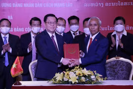 Ông Nguyễn Trọng Nghĩa, Bí thư Trung ương Đảng, Trưởng ban Tuyên giáo Trung ương Đảng Cộng sản Việt Nam và ông Khamphan Pheuyavong, Bí thư Trung ương Đảng, Trưởng Ban Tuyên huấn Trung ương Đảng Nhân dân cách mạng Lào trao thỏa thuận hợp tác giữa hai bên.
