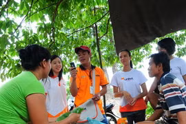 Cán bộ nhân viên Viettel tổ chức bán hàng tại một làng của Lào. (Ảnh: PV/Vietnam+)