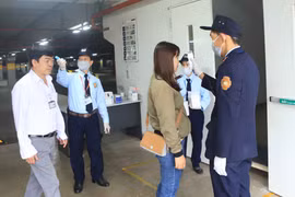 Đo nhiệt độ cho công nhân trước khi vào làm việc tại Công ty TNHH sản xuất hàng may mặc Việt Nam (TAL), khu công nghiệp Bá Thiện 2 (huyện Bình Xuyên). (Ảnh: Hoàng Hùng/TTXVN)