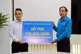 Lãnh đạo Liên đoàn Lao động tỉnh Nam Định trao tiền hỗ trợ người lao động bị thiệt hại trong vụ cháy. (Ảnh: Nguyễn Lành/TTXVN)