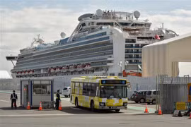 Xe buýt chở hành khách trên du thuyền Diamond Princess rời cảng ở Yokohama, Nhật Bản. (Ảnh: AFP/TTXVN)