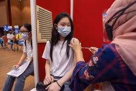 Nhân viên y tế tiêm vaccine ngừa COVID-19 cho thanh thiếu niên tại Selangor (Malaysia). (Ảnh: THX/TTXVN)