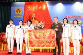 Đại tướng Tô Lâm - Ủy viên Bộ Chính trị, Bộ trưởng Bộ Công an trao tặng bức trướng của Đảng ủy Công an Trung ương cho Hội Phụ nữ Bộ Công an. (Ảnh: Phạm Kiên/TTXVN)