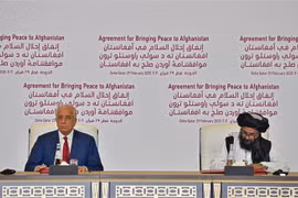 Đặc phái viên Mỹ về vấn đề tái hòa giải Afghanistan Zalmay Khalilzad (trái) và nhà đồng sáng lập phong trào Taliban Mullah Abdul Ghani Baradar tại lễ ký thoả thuận hoà bình ở Doha (Qatar), ngày 29/2/2020. (Ảnh: AFP/TTXVN)
