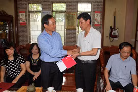 Phó Tổng Giám đốc Lê Duy Truyền trao sổ tiết kiệm cho thân nhân liệt sỹ Lê Duy Quế. (Ảnh: Thanh Tùng/TTXVN)